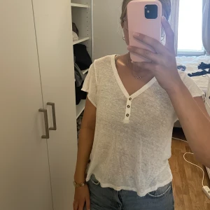 Vit T-shirt  - Vit T-shirt med knappar framtill. 