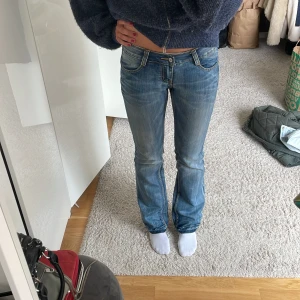 Lågmidjade jeans - Midjemått rakt över svart knapp: 41cm Midjemåttet rakt över silver knapp: 39 cm Gylf: 18cm Total längd: 107cm Sprättade längst ner 