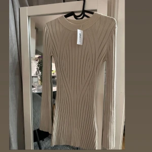 Beige låmgärmad klänning - Helt oanvänd Beige klänning som är väldigt fin och söt till ett par botz, långärmad i storlek xs