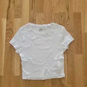 En vit t-shirt som man kan styla på många olika sätt. Den är i storlek xs.💕