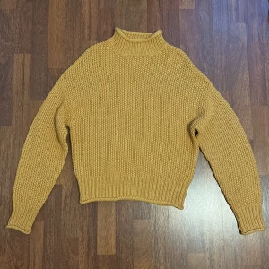 Stickad tröja - Stickad tröja med krage. Färgen är orange/gul (färgen syns bättre i andra bilden)