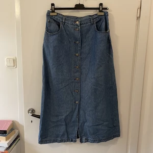 lång jeanskjol - supersnygg jeanskjol!! till anklarna på mig som är 171! oanvänd av mig men köpt secondhand:) enligt lappen är storleken 42 men det beror på hur man vill att den ska sitta