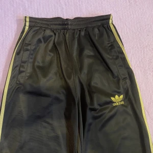 Adidasbyxor  - Vintage bruna adidas byxor med guldiga streck. Barnstorlek xl så skulle säga att den passar xxs/xs/s🪐Möts gärna upp men kan även frakta (frakten kostar 66kr)🤎