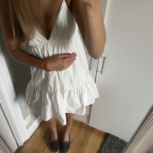 Vit klänning från Zara - Älskar den här söta vita klänning från Zara!🤍sitter perfekt runt kroppen och är så fin i ryggen. Klänningen är justerbar, vilket gör att det går att göra den större eller mindre runt bysten genom att knyta banden i ryggen lösare eller tajtare.🩷 