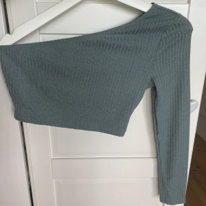 Grön topp - Grön topp med en arm. Ifrån shein. Använd några enstaka gånger och är i fint skick. Storlek S. Går bra för att använda ”köp nu” annars skriv ett meddelande!☺️