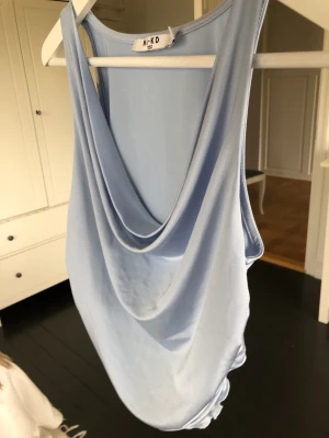 Aldrig använd, fin topp - Riktigt härlig topp från na-kd. Har tyvärr aldrig kommit till användning. Ljusblå och fint fall på urringningen fram. 