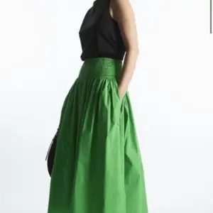 Helt ny, aldrig använd kjol. Säljs nu på COS för 790 kr. Passar en storlek 36-40 skulle jag säga då midjan är så elastisk.   För mer info se: https://www.cos.com/en_sek/women/womenswear/skirts/product.smocked-midi-skirt-green.1174712001.html