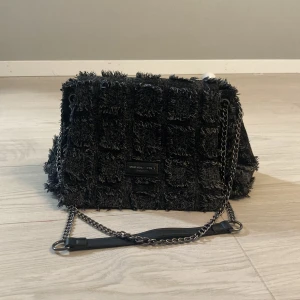 fransig axelremsväska - Så fin fransig axelremsväska i denim material, smart till precis allt. Rymmer ett helt ombyte. Bandet går att förlänga.