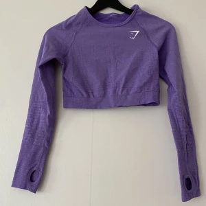 Gymshark crop top - Långärmad croptop från Gymshark, deras ”vital seamless” i bright purple marl. Helt slutsåld hos gymshark!! Fantastiskt skick, endast använd 1 gång 💜💜 Lapp i nacken är bortklippt.