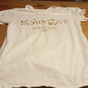 En vit t-shirt med guld text på 