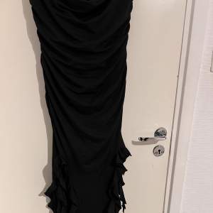 En svart klänning från Bershka med volanger i botten. Klänningen är aldrig använd och köpt för några månader sen.