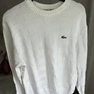 Säljer denna vita stickade tröja från Lacoste som är i mycket bra skick storlek m
