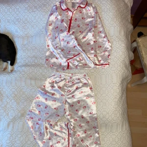 Hello Kitty Pyjamas  - Säljer detta jättesöta HelloKitty pyjamas setet & en HelloKitty Pyjamas skjorta tsm!🐱 Skjortorna har lite "repor" & skjortan som är själv har jag byt ena knappen på men det syns inte tydligt, annars är det i bra skick!❤️🤍 Skriv för mer info & 📸! Buda!