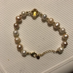 Äkta pärlarmband - En pärlarmband med äkta pärlor från Khai. Gjort i guldpolerat rostfritt stål så det inte färgar av sig med justerbart spänne 