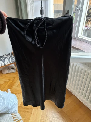 Satin kjol  - Svart satin kjol från NaKd med ett midjeband.