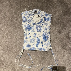 Söt blå topp med knytningar - Söt topp från shein. Använt 1 gång utomlands. Köpt i somras. Storlek S. Man kan dra banden i sidan så dne blir kortare eller knyta banden. Knytning fram mot bröstet