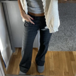 Lågmidjade kostymbyxor strl 34 - Gråa lågmidjade kostymbyxor med blåa detaljer. Upp sydda så går att sprätt upp för att bli längre. 