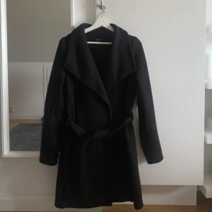 Svart kappa - Svart kappa i storlek L från Vero Moda. Kappen är liten i storleken därav sitter en L bra på mig som vanligtvis är en strl S!💛