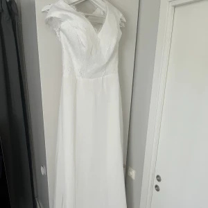 Ny brudklänning  - Oanvänd pga sen leverans. Stl S/M Dragkedja (knappklädd) Passar 168-173 cm lång person, går såklart att lägga upp.  Oanvända spetsskor / 38-39