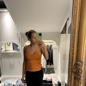 Topp - En jätte snygg organge glittrig topp, den e väldigt flexibel i strolek i med att man knyter åt den där bak så passar många. 