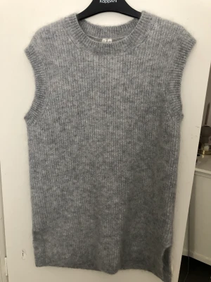 Arket stickad väst - Säljer mina stickade väst från Arket som är helt ny. Har en liten slits på sidorna. Så snygg som den är eller med en tröja under. Köpt för 690 kr. 