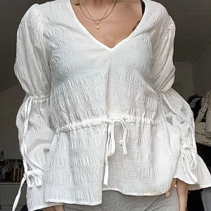 Struktur blus - Strukturerad blus från Nelly med många söta detaljer i strl S! Armarna ska knytas med rosetter🤍 OANVÄND🩷 använd gärna köp nu🥳