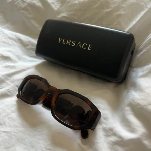 Versace solglasögon  - Säljer mina Versace solglasögon i modellen BIGGIE UNISEX färg Havana. Använda 2 gånger. Köpta på NK i Stockholm.  Nypris 2645 kr. 