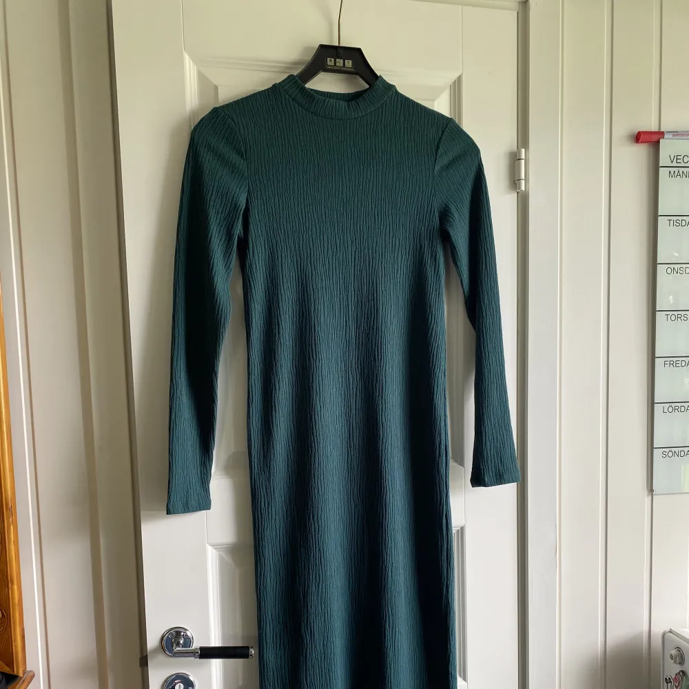 Lång mörkgrön klänning från Lindex strl XS, men den är stretchig i tyget så passar någon med S även. Använd ett fåtal gånger. . Klänningar.