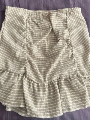 Beige volangkjol  - Kort beige kjol från Gina Tricot. Har använts en gång 