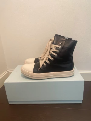 Rick Owens DRKSHDW Sneakers - Rick Owens DRKSHDW hightop sneakers i svart. Nyskick, knappt använda alls. Storlek 42. Osäker om de är äkta då jag fått de och kvittot är slängt.. Säljes då det inte riktigt min stil. 