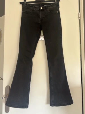 Svarta bootcut jeans med låg midja - Säljer ett par svarta bootcut jeans med låg. Materialet är stretchigt denim som sitter snyggt och bekvämt. Referens jag är 155 cm. Obs säljer endast via plicks köpknapp. 