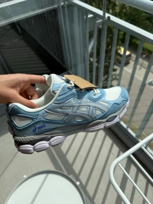 Asics vita och ljusblå sneakers - Snygga sneakers från Asics i vitt och ljusblått med mesh- och mockadetaljer. Helt nya och oanvända. 