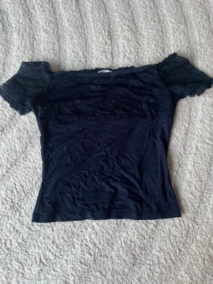 Tröja från Gina Tricot - Tröja från Gina Tricot med spetsdetaljer!!💕 Använts 3 ggr och har inga skador, som de syns på bild 3 har tröjan en ”halkskydd” som ser till att tröjan inte glider ned 