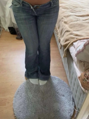 Vintage low waist bootcut jeans med fjäril fickor - Otroligt fina och unika vintage jeans som är blå. Bilder från tidigare ägare då dom tyvärr är för stor för mig🥲 Lite slitage ner till men annars i super fint skick. Skulle säga runt storlek S-M. Pris går att diskutera😊 Dessutom lite lång för mig som är 162cm💗 Midja: 38cm Innerben: 78cm Ytterben: 97cm 