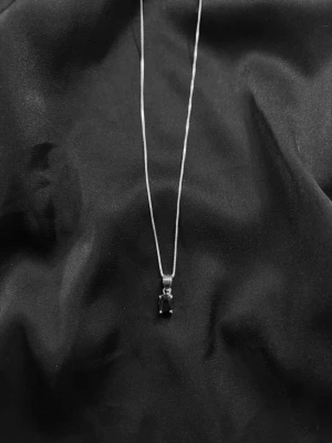 Silverhalsband med svart sten - Halsband i äkta silver med en tunn kedja och ett hängsmycke med en svart sten. Aldrig använd och i vädligt fint skick.