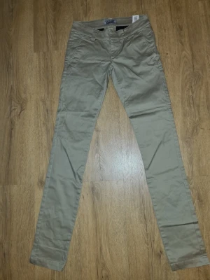 Beige chinos med smal passform - Snygga beige chinos med smal passform och klassiska fickor fram. Byxorna har bälteshällor och stängs med dragkedja och knapp. Tillverkade i ett mjukt och bekvämt bomullsmaterial som passar perfekt till en avslappnad stil. Khaki färgad.