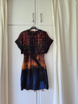 Design Mr Christian Lacroix från Desigual, S/M - Klänning i 100% bomullstrikå, något kraftigare kvalitet än en t-shirt. Helt ny, oanvänd och utan defekter. Kvitto saknas däremot. Storlek S som passar även för M. Längd: 90 cm. Byst: mellan ca 88-98 cm, den är vid över bysten. Midja: ca 70-75 cm. Höft: passar ca 92-97 cm. Ganska figurnära. Typisk vår, sommar- och höstklänning.