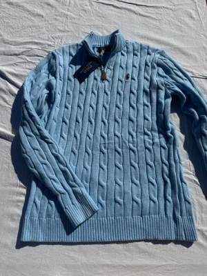 Ljusblå kabelstickad tröja Polo Ralph Lauren - Tjena säljer denna snygga quarterzipen med en unik blå färg. Denna får dig verkligen att sticka ut samtidigt som du ser riktigt stilig ut. Priset går att diskutera vid snabb affär, och för fler bilder eller vid fundering är det bara att skriva//Felkannn