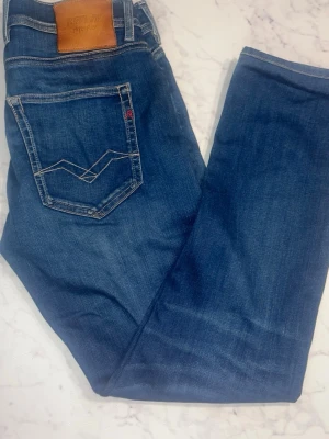 Replay Grover jeans - Säljer ett par Replay Hyperflex Grover jeans i klassisk blå färg med raka ben och snygga kontrastsömmar. Modellen har straight fit och är storlek 29/32