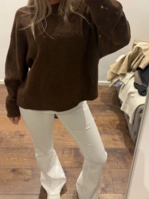 Brun oversized stickad tröja - Mysig oversized stickad tröja i mörkbrunt med rund halsringning och långa ärmar. Perfekt för lager på lager och enkel att styla med olika outfits. Tröjan har en avslappnad passform och mjukt material.