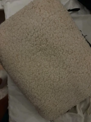 Beige fluffig datorväska med dragkedja - Supermjuk och fluffig datorväska i beige teddy-material. Väskan har en rektangulär form och stängs med en kraftig silverfärgad dragkedja längs ena långsidan. Perfekt för dig som vill ha en mysig och trendig look till din laptop.