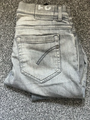 Ljusgrå jeans från Dondup - Snygga ljusgrå jeans från Dondup, tillverkade i Italien. Klassisk femficksmodell med raka ben och diskreta sömmar. Perfekta för dig som gillar en stilren och avslappnad look. Materialet är mjukt denim som sitter skönt hela dagen.