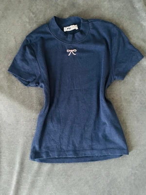 Fin tröja  - Blå tight t-shirt med en gullig rosett från New Yorker💕