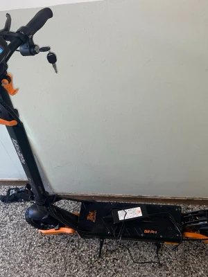 El-scooter Kaabo G2 Pro svart/orange - Säljer en Kaabo G2 Pro el-scooter i svart och orange med robust ram i metall. Scootern har nyckelstart, stora hjul och baklyse för extra säkerhet. Perfekt för smidig transport i stan och har sportig design med tydliga detaljer.