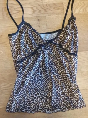 Y2k texturad leopard linne - En y2k leopardmönstrad linnetopp från märket green coast🙌🏻 köptes på en vintage butik i Portugal. Storlek 42, skulle säga att den passar S/M beroende på byst storlek. tunna axelband och svarta spetsdetaljer🫶🏼 linnet har en textur till sig
