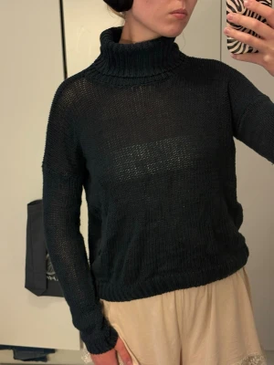 Stickad polotröja - Stickad polotröja med lös passform och ribbade muddar vid ärmslut och nederkant. Tröjan har en hög, vikt krage och är tillverkad i ett tunt, lätt material som ger en avslappnad look. Perfekt för lager-på-lager-stil.