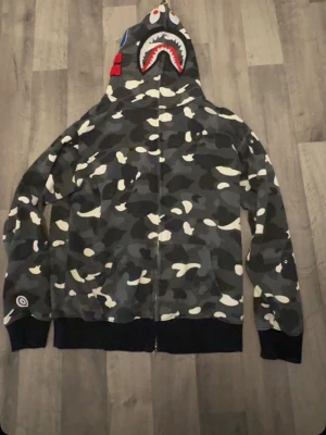 BAPE Shark camo zip hoodie - Säljer min BAPE hoodie då den inte används längre. Bra skick utan större defekter. Passar perfekt om du gillar streetwear.