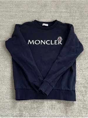 Moncler Sweatshirt - Tja! Säljer nu denna feta Moncler sweatshirten! Den är i riktigt bra skick som ni ser på bilden. Storleken är 14 år, eller 164 cm, men jag skulle säga att den passar upp till 168 cm.              Nypris: 3000 kr❌‼️Mitt pris: 699 kr ✅. Skriv vid minsta fråga eller fundering och pris kan diskuteras!🤝