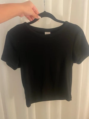 T-shirt  - En svart T-shirt från Gina som inte kommer till andvändning 