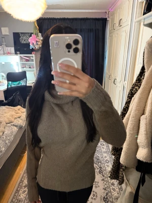 Stickad tröja - Mysig beige stickad polotröja med avslappnad passform och långa ärmar. Tröjan har en bred polokrage och ribbade muddar vid ärmslut och nederkant. Perfekt för kalla dagar och enkel att matcha med olika outfits.